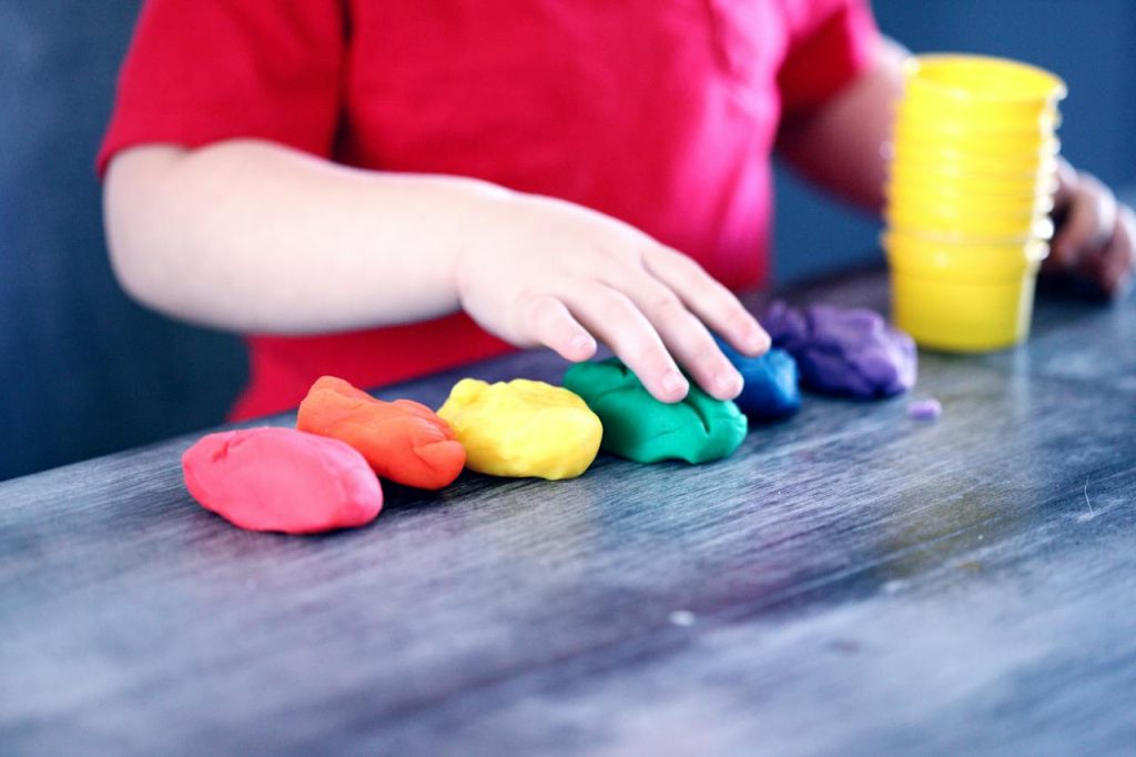 Child lining up play dough