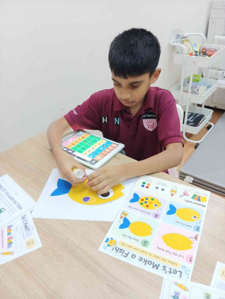 Boy using an AAC device to communicate during a lesson in school