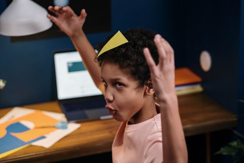 Child making funny faces instead of doing homewokr