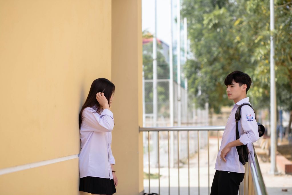 Boy and girls at school balcony. Girls seemingly upset
