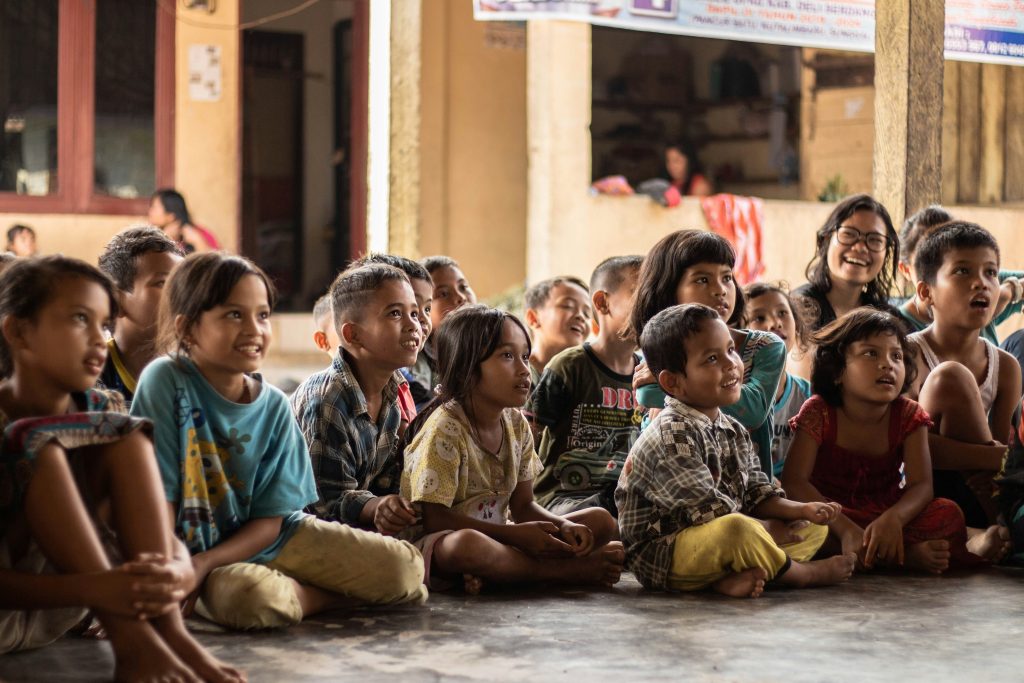 Group of children sitting on the floor happily and smiling 